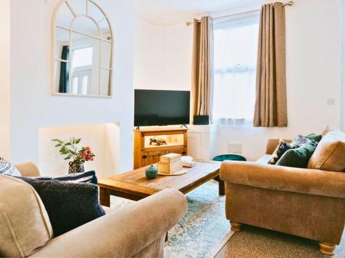 a living room with two couches and a table at Central 3 Bed Home, Contractors, Garden, Fast WiFi, Smart TV in Saint Helens