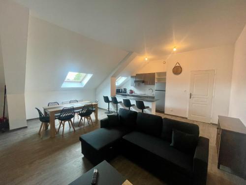 a living room with a couch and a table with chairs at Business Apparts Caudry in Caudry