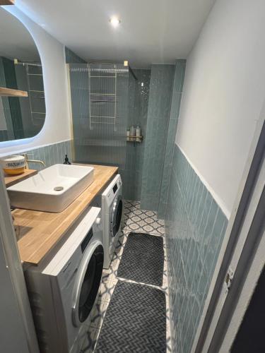 a bathroom with a washing machine and a sink at IVY - Classical & modern apartment in lovely neighbourhood near beach in The Hague