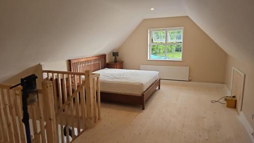 a bedroom with a bed and a staircase with a window at lakeview Guesthouse Virginia in Lisgrea