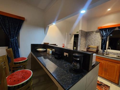 a kitchen with a black counter top with two stools at Villa Admiral in Praslin