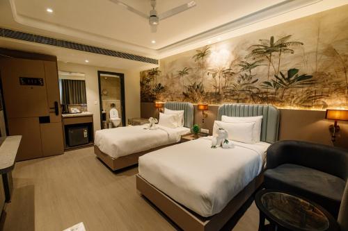 a hotel room with two beds and a couch at Pride Premier Alwar - Sariska in Alwar
