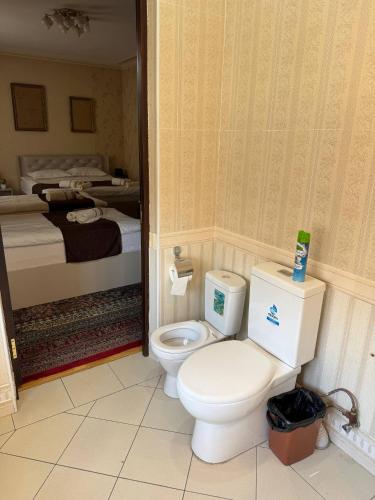 a bathroom with a toilet in a room with a bed at Узбечка in Tashkent