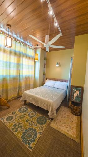 a bedroom with a bed and a ceiling fan at 18 Camella in Baguio