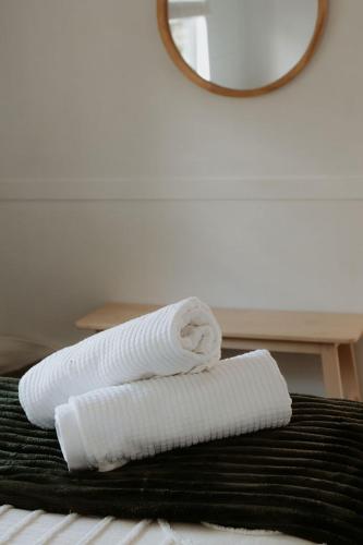 a rolled up white towel sitting on top of a bed at Pine Cottage in Dennes Point