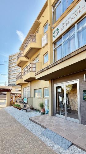 a building with a bench in front of it at Tabist International Hotel Kaike in Yonago
