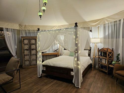 a bedroom with a canopy bed with lights on it at Clouds Serenity in Beechmont