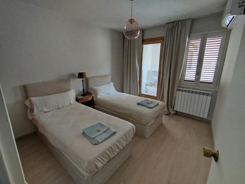 a hotel room with two beds and a window at Cozy rural apartment in Calaceite