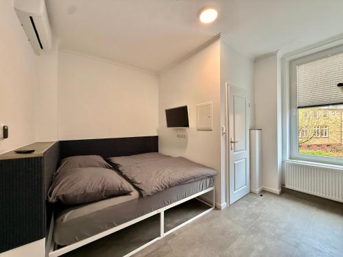 a small bedroom with a bed and a window at Smart Business Studio in Itzehoe