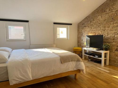 a bedroom with a bed and a flat screen tv at Studio Douillet in Mâcon