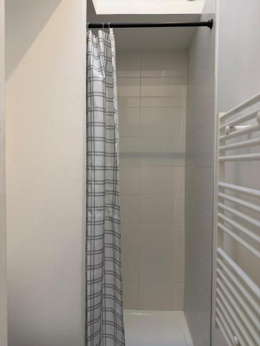 a shower curtain in a bathroom with white walls at Studio Douillet in Mâcon