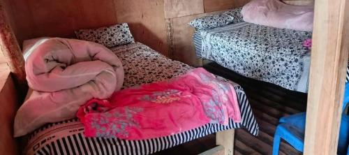 a room with two bunk beds in a room with at Rara Sunrise Hotel in Chautha