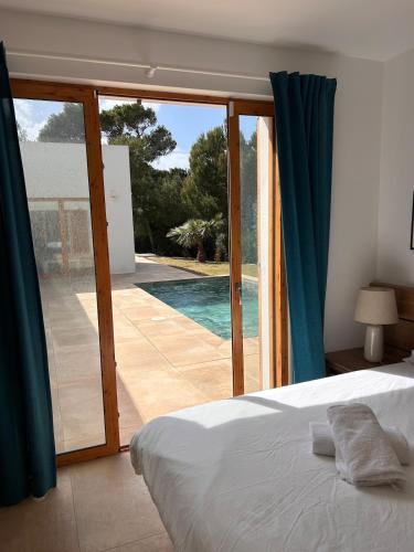 a bedroom with a bed and a view of a swimming pool at Vivez Cala Morell! in Cala Morell