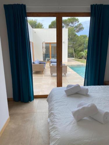 a bedroom with a bed and a view of a pool at Vivez Cala Morell! in Cala Morell