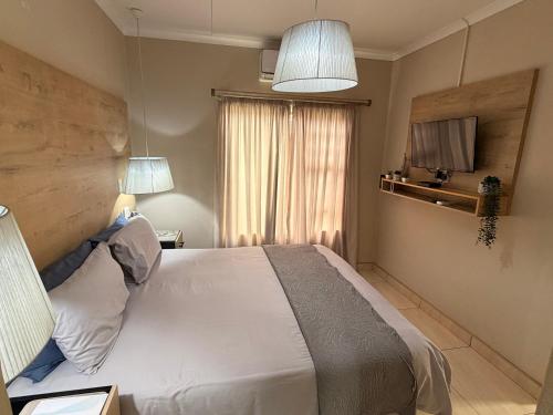 a bedroom with a white bed and a window at On Smook in Zeerust