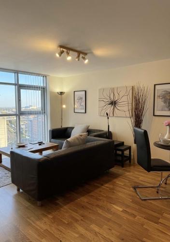 a living room with a black couch and a table at Cardiff City Center - FREE On-Site Parking in Cardiff