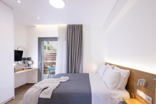 a bedroom with a bed and a desk with a television at Enalis Studios & Apartments in Karfas