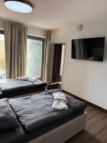 a bedroom with two beds and a flat screen tv at GARLAND Rooms in Bremen