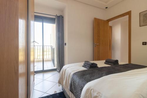 a bedroom with a bed and a sliding glass door at Blue Waves 2 Bedrooms with Pool in Bouznika