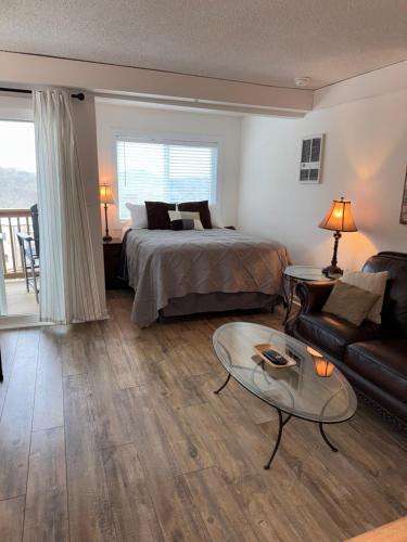 a bedroom with a bed and a couch and a table at Sugar Ski & Country Club in Sugar Mountain