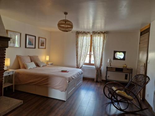 a bedroom with a bed and a table and a chair at La maison Argonnaise in beaulieu en argonne