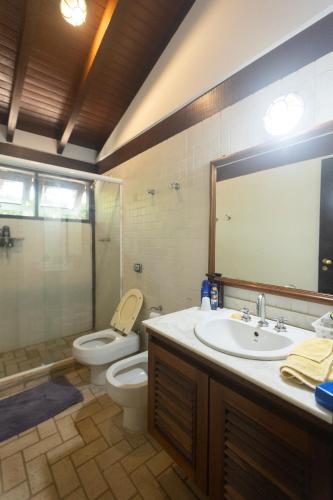 a bathroom with a sink and a toilet and a shower at Casa Jataí Guest House in Barra do Sahy