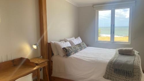 a bedroom with a bed with a view of the ocean at Binks at Sea in Witsand