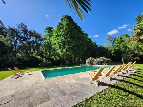 a group of chairs next to a swimming pool at Cabaña La Mechita con jacuzzi privado in Estación Delta