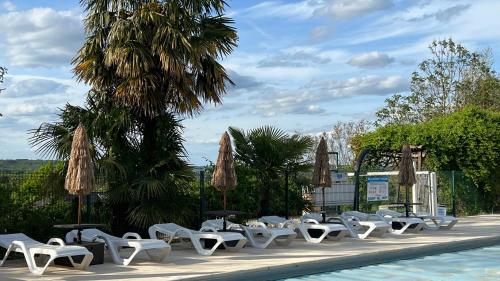 a row of white chairs and a swimming pool at Residence Les Villas CROMA in La Roche-Posay