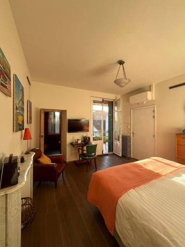 a bedroom with a bed and a living room at Le Domino Chambres d'Hôtes et Restaurant in Draguignan