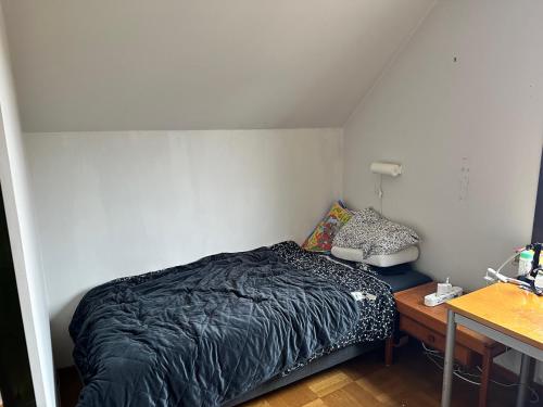 a small bedroom with a bed and a desk at Rum i villa Burlöv in Arlöv