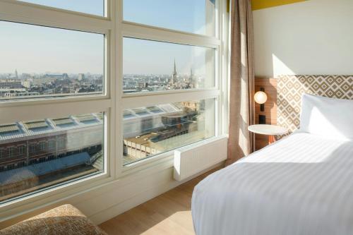 a bedroom with a bed and a large window at Residence Inn by Marriott Lille in Lille