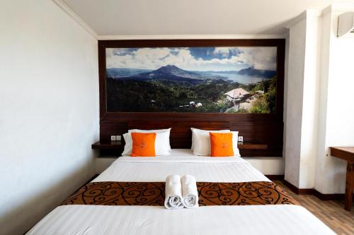 a bedroom with two beds with a painting on the wall at Nusa Dua Moon Hotel in Nusa Dua
