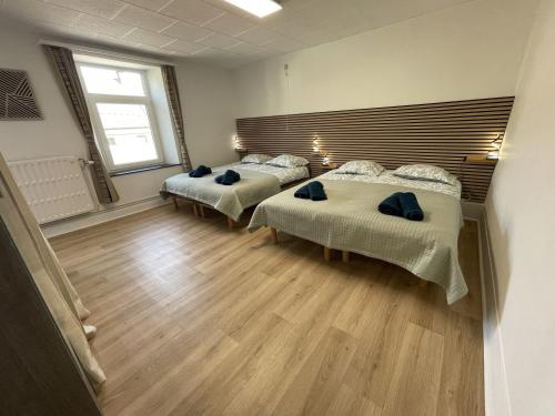 a bedroom with two beds and a large window at Gite Au Fil du Temps in Walcourt