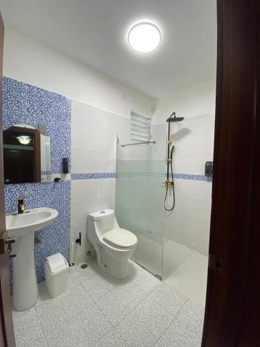 a bathroom with a shower and a toilet and a sink at CEDOTURT Hotel Boutique & Escuela in Santo Domingo
