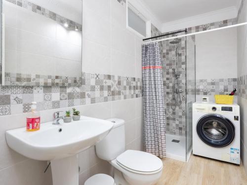 a bathroom with a sink toilet and a washing machine at Vivienda del mar in Arico