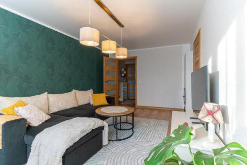 a living room with a couch and a green wall at One bedroom apartment in Viljandi