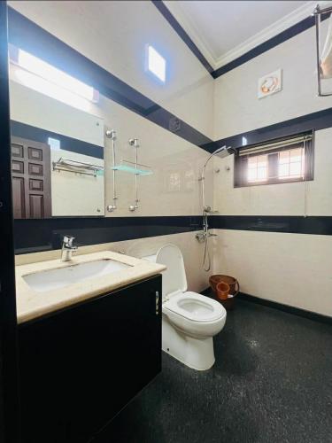 a bathroom with a white toilet and a sink at solomons ark luxury pool villa in Cochin