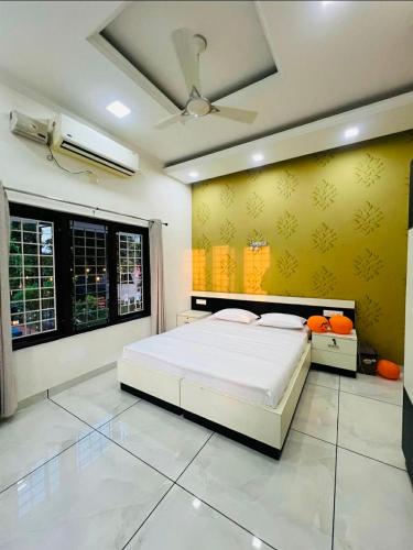 a bedroom with a bed and a yellow wall at solomons ark luxury pool villa in Cochin