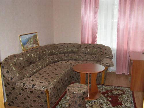 a couch in a living room with a table at ABBA Hotel in Kyiv