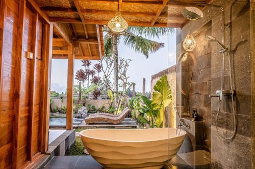 a bathroom with a large tub and a shower at Kubu Tama Villa in Tegalalang