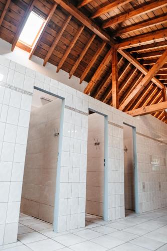 a row of three stalls in a building with wooden ceilings at Belle Tent - Camp La Belle Vie in Berdorf
