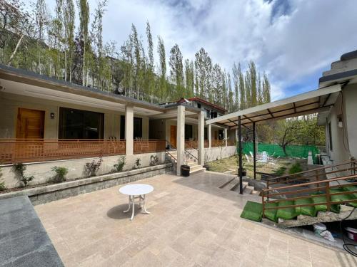 a patio of a house with a table and a bench at Pak Himalaya Hotel Kachura in Ponedas