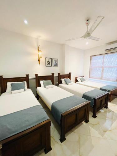 a room with four beds and a window at Grand Rockland Hotel in Matara
