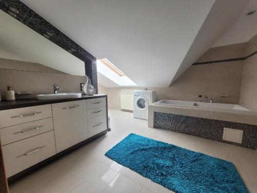a bathroom with a sink and a bath tub and a rug at Lake Hill Giżycko in Giżycko