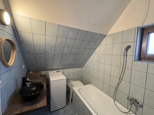 a bathroom with a tub and a toilet and a sink at Valéria Vendégház in Budakalász