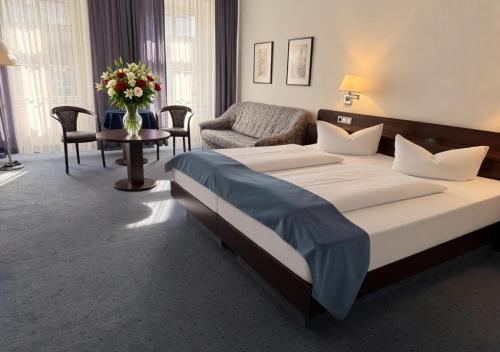 a hotel room with a large bed and a chair at Hotel Goldener Adler in Bautzen