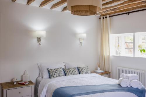 a white bedroom with a bed with towels on it at The Ash Tree in Ashendon