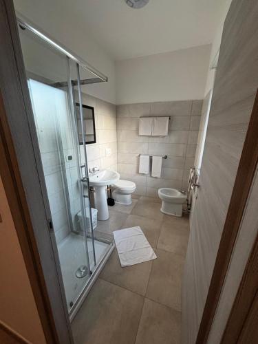 a bathroom with a shower and a toilet and a sink at L'imbarco ROOMS in Badolato Stazione