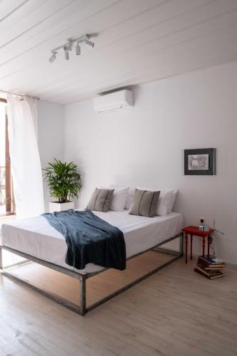 ein Schlafzimmer mit einem großen Bett in einem weißen Zimmer in der Unterkunft Araldo in Chania